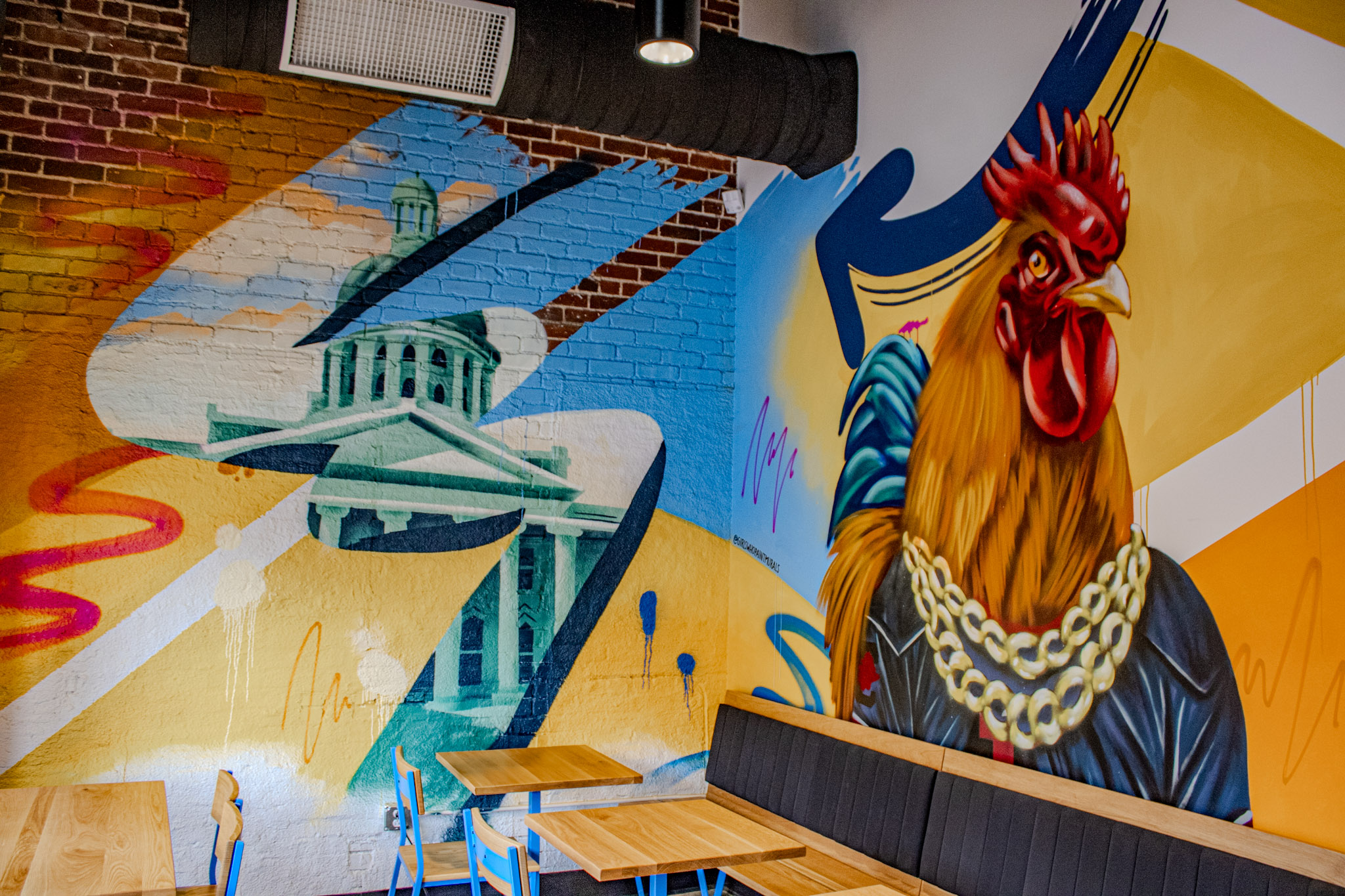 Mural of the South Carolina State House and a gold-chained rooster on the dining room wall