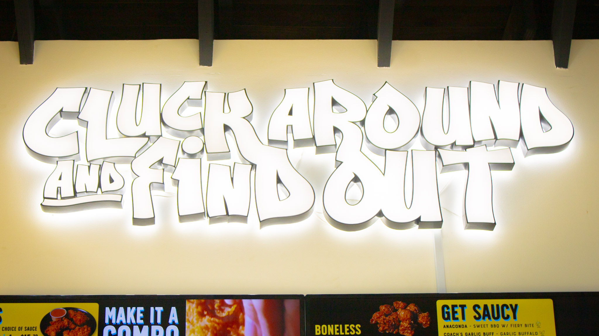 Cluck Around and Find Out neon sign above the counter at Cocky Rooster Columbia