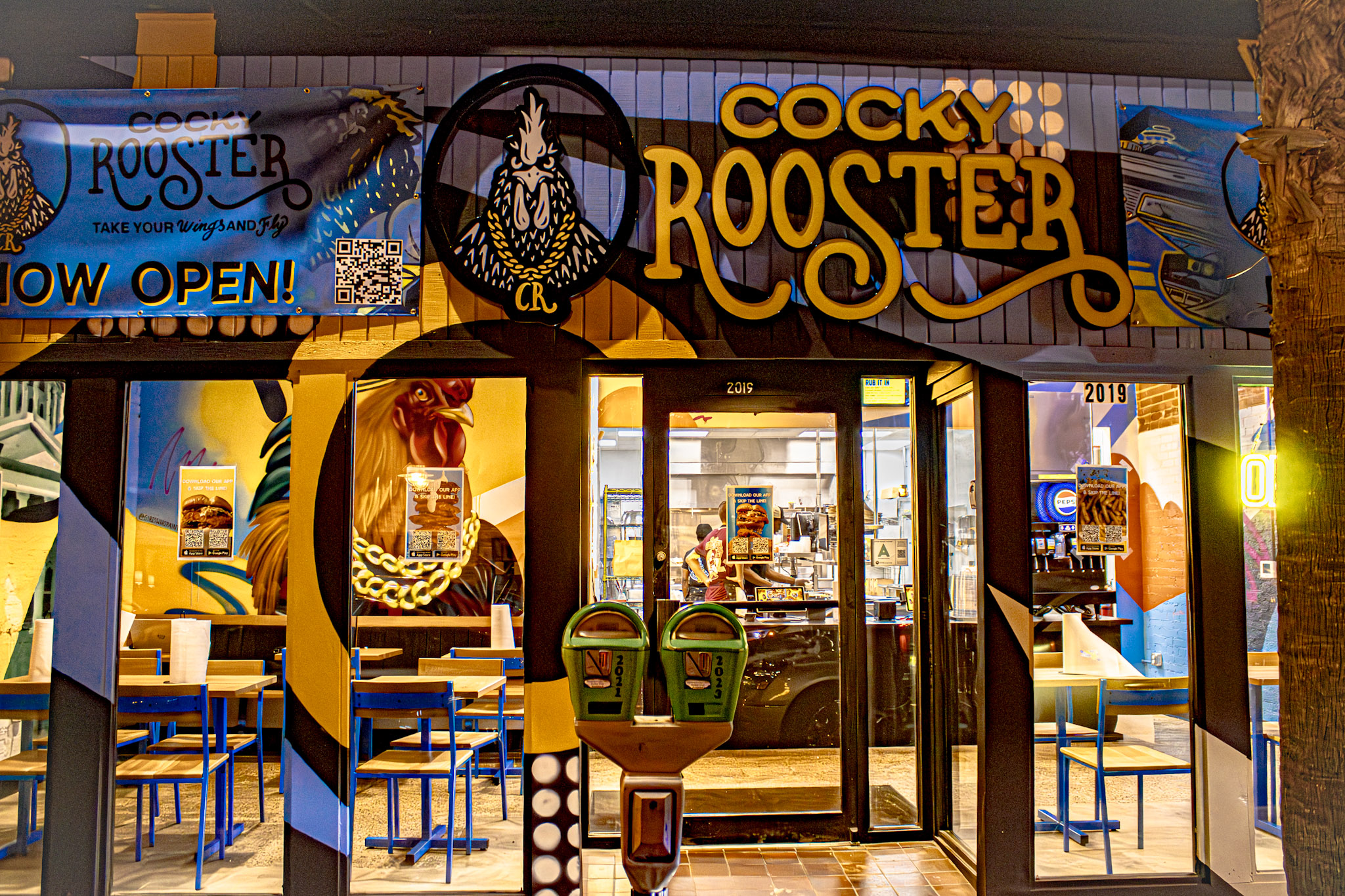 Cocky Rooster Columbia lit up at night with the Now Open sign in the window