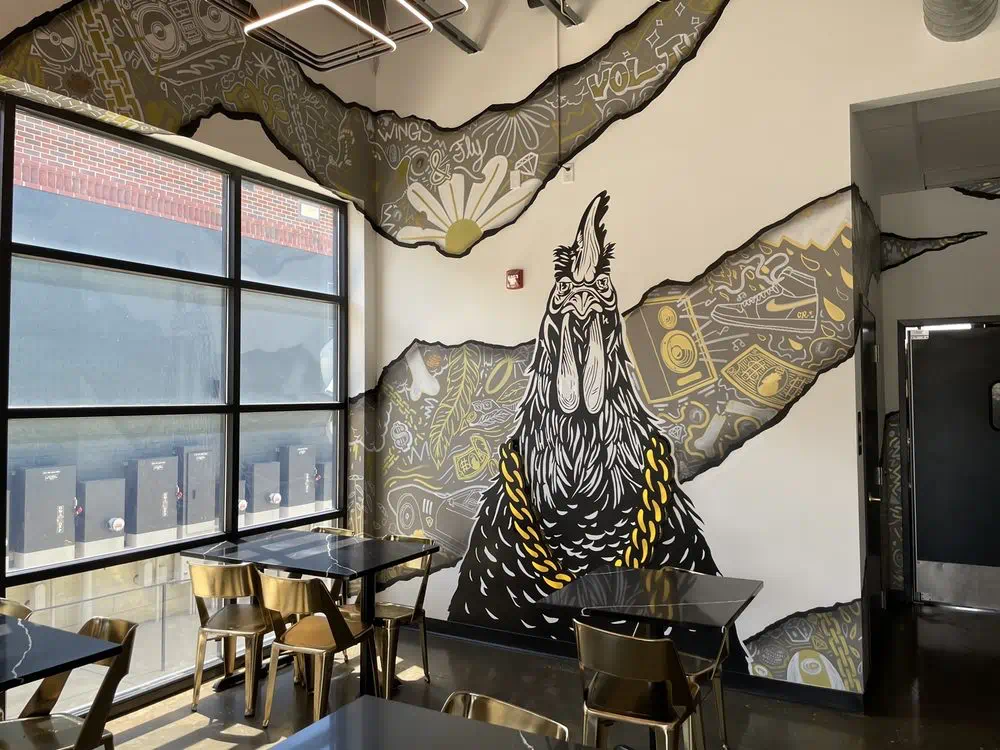 Rooster mural and tables by the front windows, daylight coming in