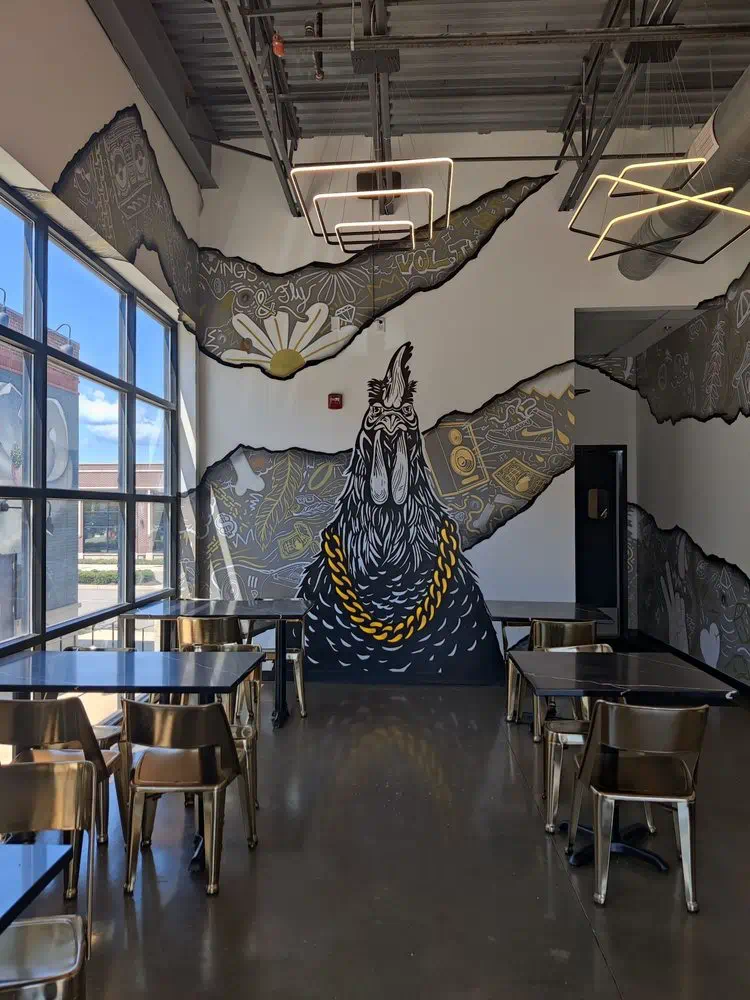 Sunlit dining area with the rooster mural and window seating