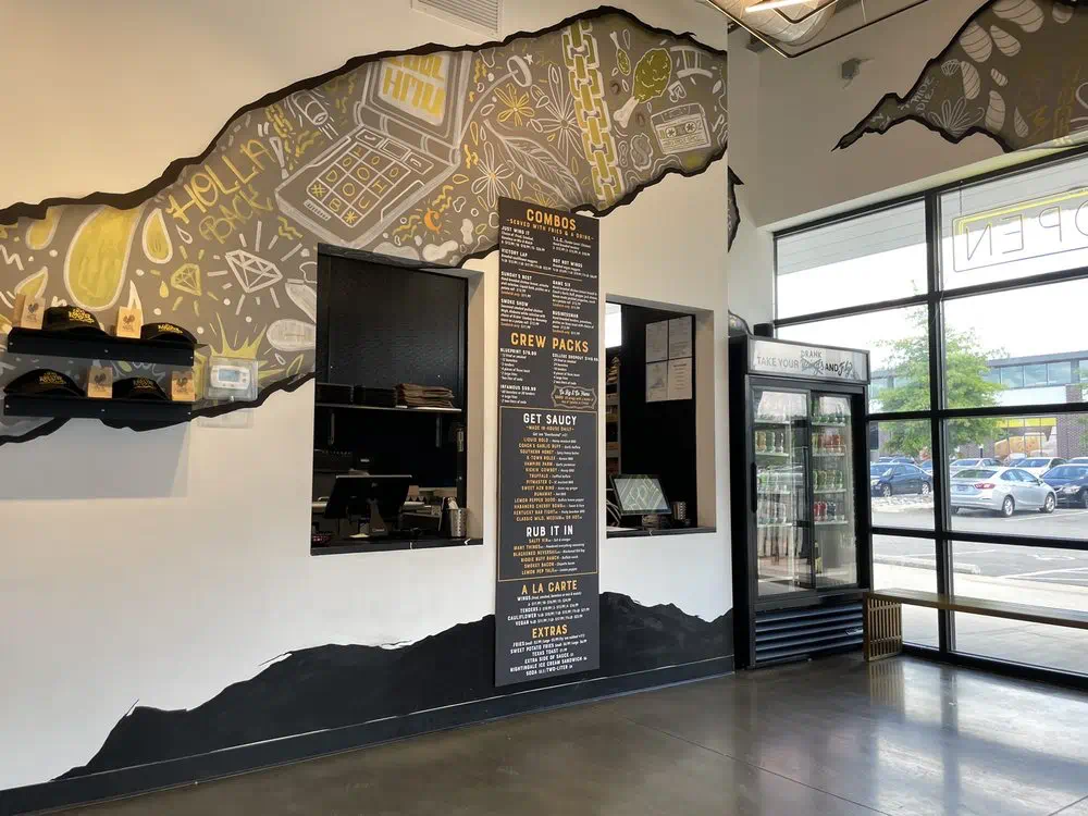 Chalkboard menu by the drink cooler and front entrance