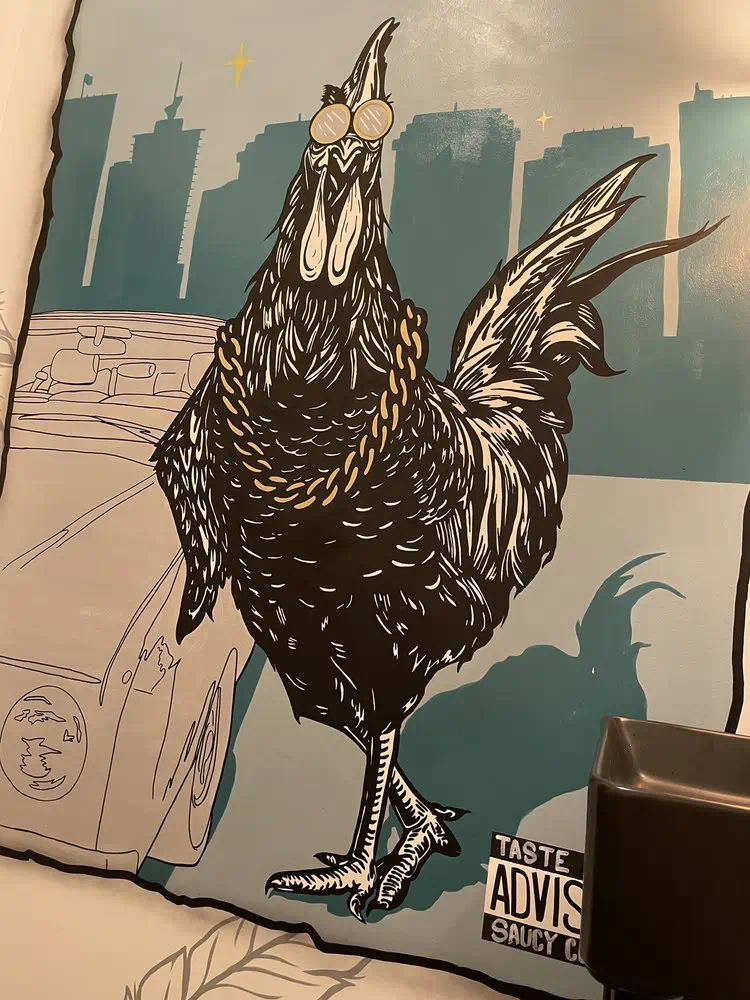 Rooster in a chain mural on the teal wall