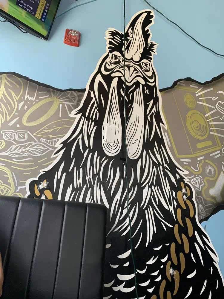 Close-up of the black rooster mural with a gold chain