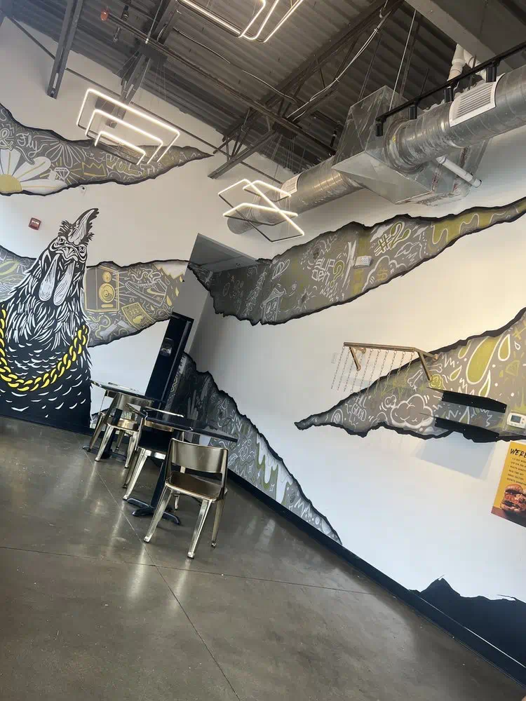 Black rooster with a gold chain mural at the corner of the dining room