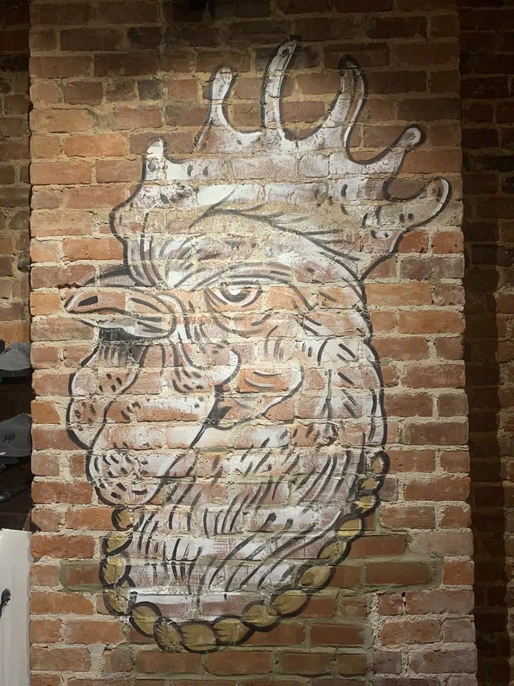 Close-up of the rooster mural on the red brick wall